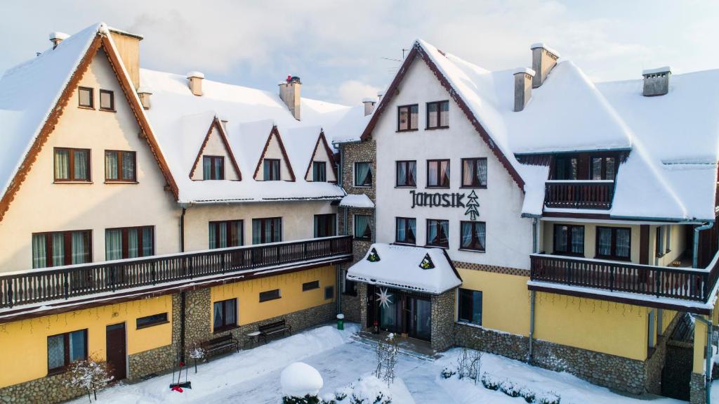 a group of buildings with snow on the roofs at DW Janosik in Muszyna