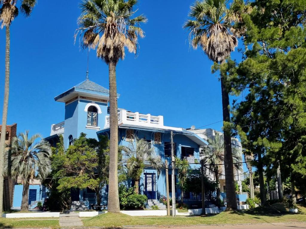 une maison blanche avec des palmiers devant elle dans l'établissement Rambla Atlantida Villagio, à Atlántida