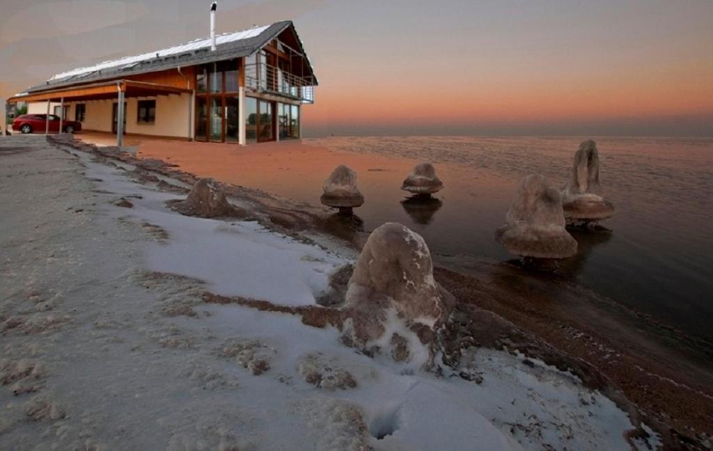 ein Gebäude am Strand mit Schnee und Eis in der Unterkunft Noclegi NaFali Rewa in Rewa