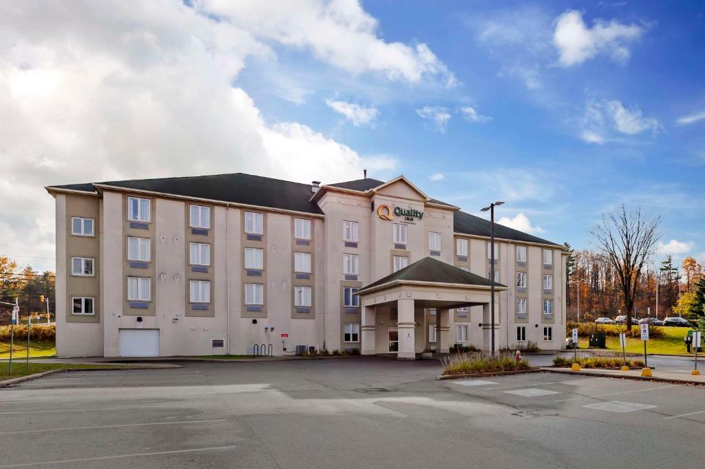 a large tan building with a black roof at Quality Inn in Ottawa