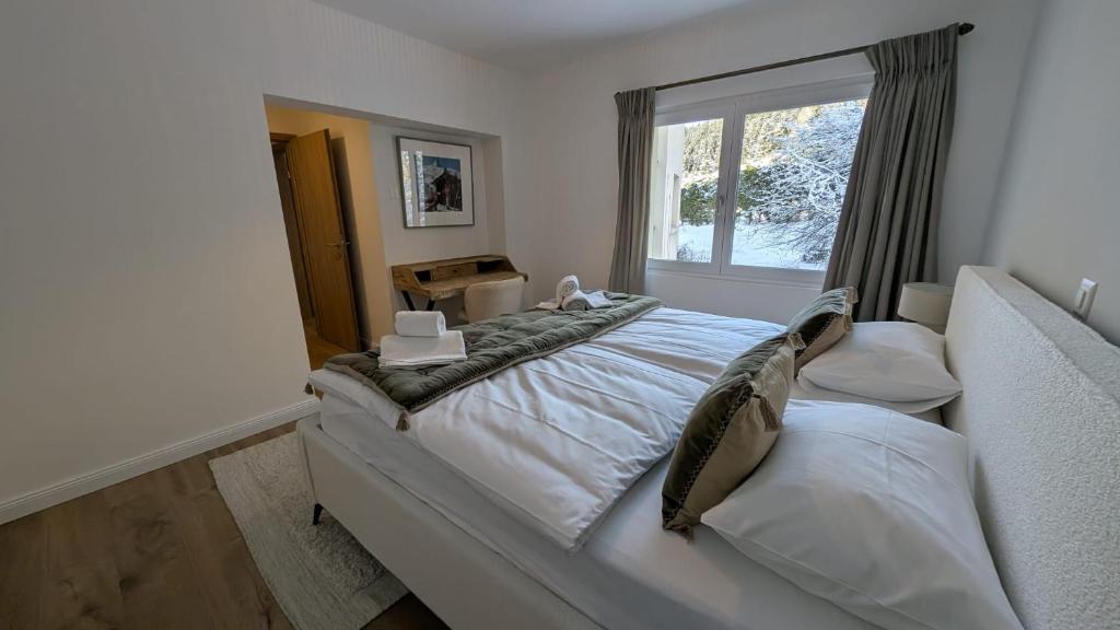 a bedroom with a large bed and a window at Le Belvedere By Alaïa in Crans-Montana