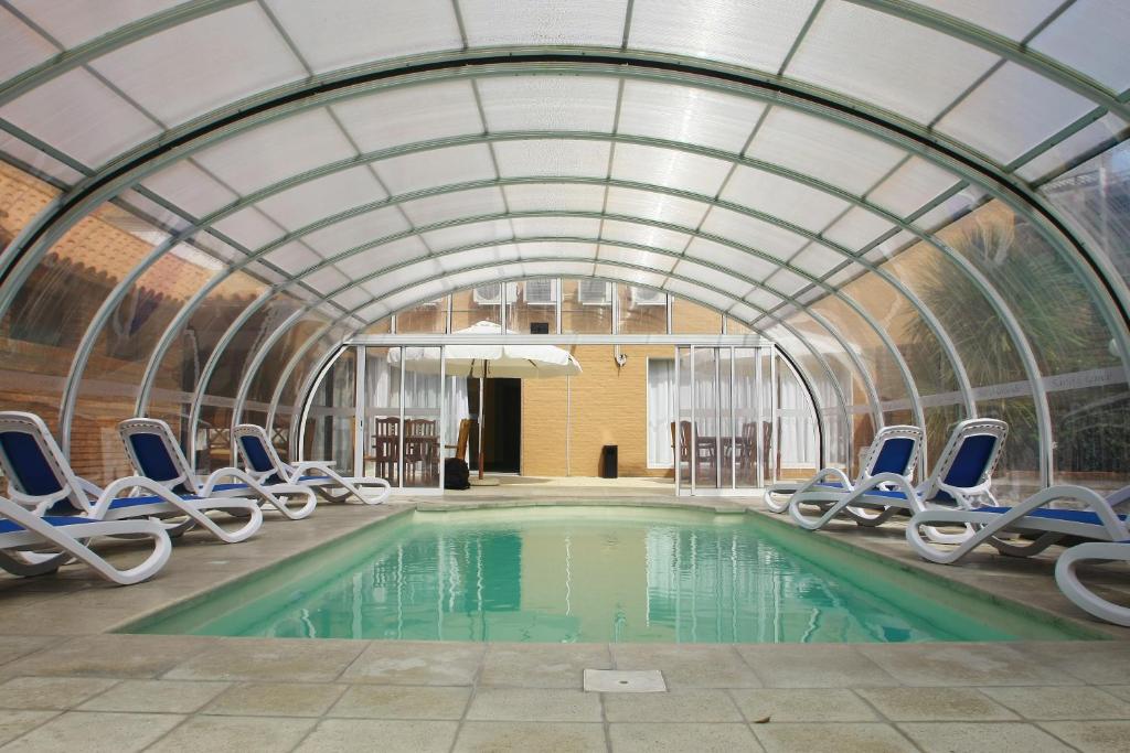 - une piscine avec des chaises dans un bâtiment en forme de dôme dans l'établissement Salto Grande Hotel, à Punta del Este