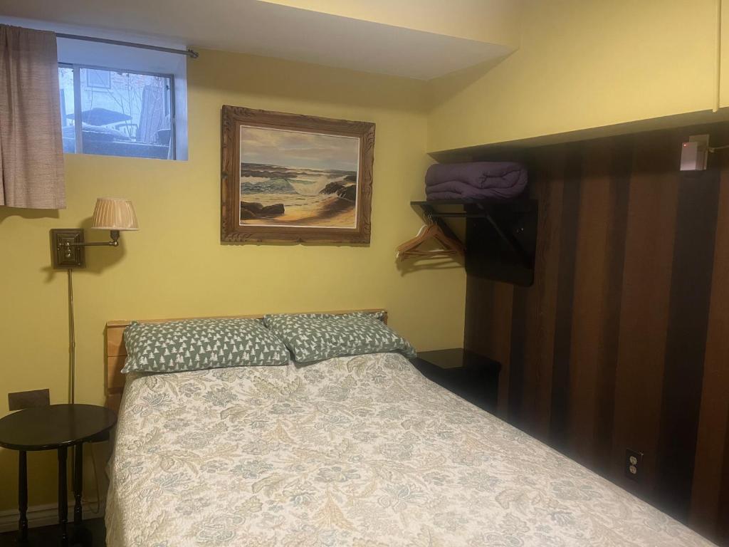 een slaapkamer met een bed en een foto aan de muur bij Pring Guesthouse in Hamilton