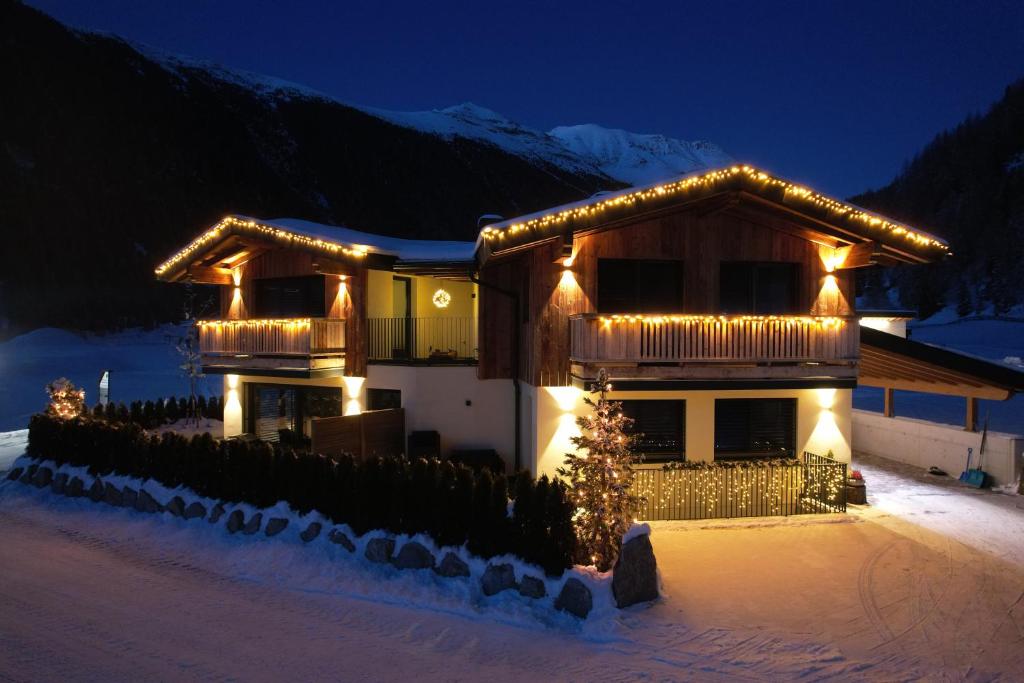 Una casa con le luci di Natale sulla neve di Alp Apart Niederthai a Umhausen