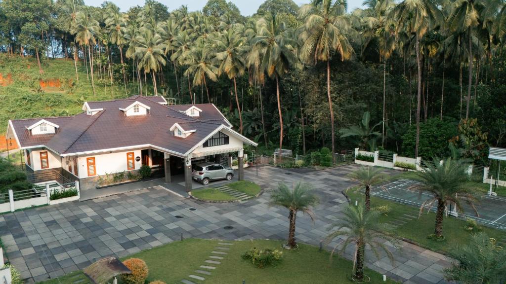 eine Luftansicht eines Hauses mit Palmen in der Unterkunft The Tales - Luxury Private Pool Resort in Kozhikode