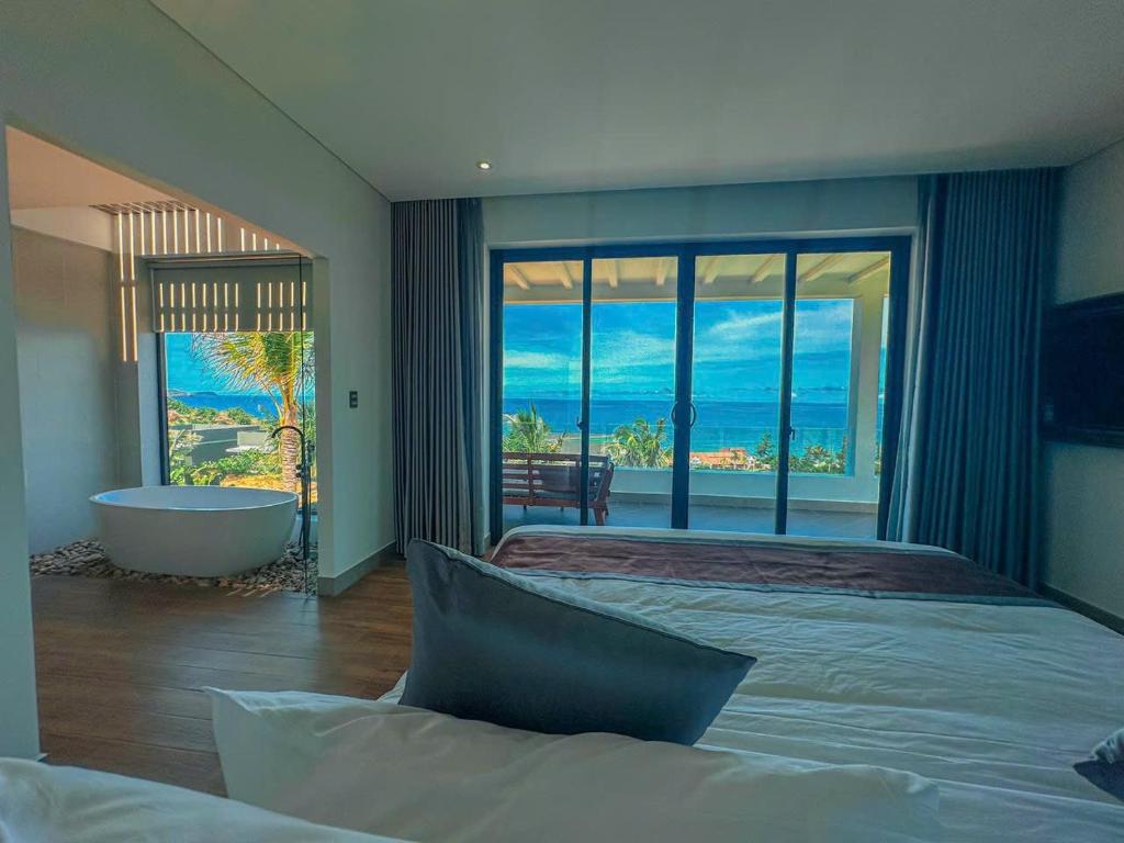 um quarto com uma banheira e um quarto amplo com vista em Du Parc Mũi Né Resort - ꜱᴀɴᴅ ᴅᴜɴᴇ & ᴏᴄᴇᴀɴ ᴠɪᴇᴡ em Mui Ne