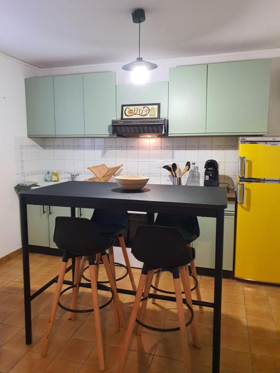 une cuisine avec une table noire et 4 chaises dans l'établissement Studio Le Petit Baigneur, à Aytré