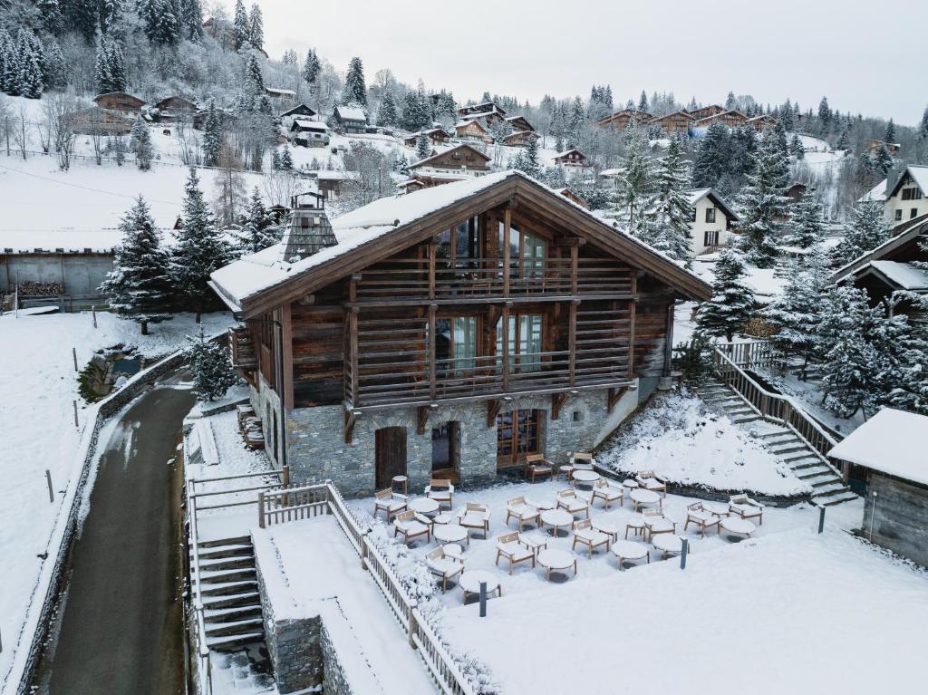 een grote blokhut met sneeuw op de grond bij Zannier Le Chalet in Megève