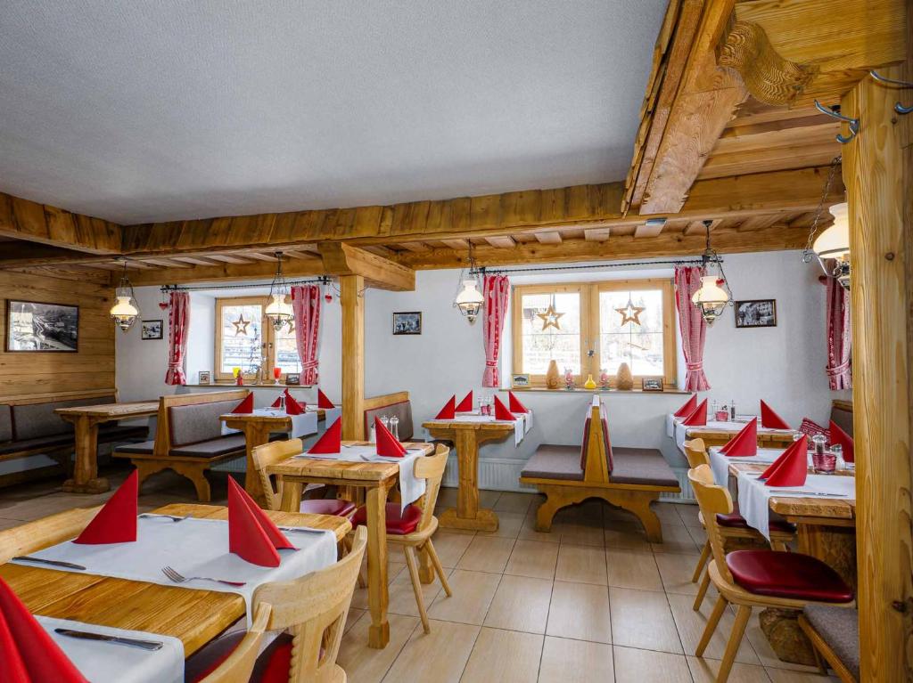 - un restaurant avec des tables et des chaises avec des serviettes rouges dans l'établissement Gasthaus Auwirt, à Fieberbrunn