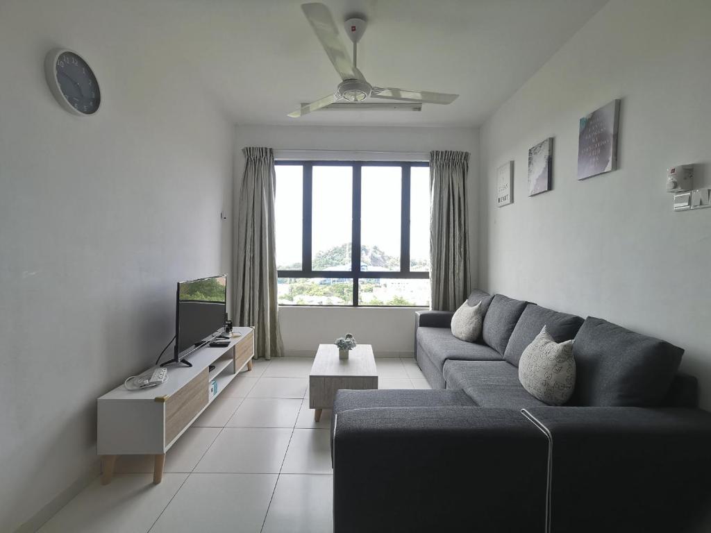 Cozy Condo at Melaka Top Hill, 7-9pax في آير كيروه: غرفة معيشة مع أريكة وتلفزيون