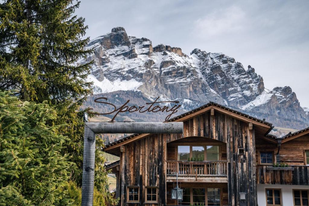 a sign for a resort with a mountain in the background at Sportony Mountain Lodges in La Villa