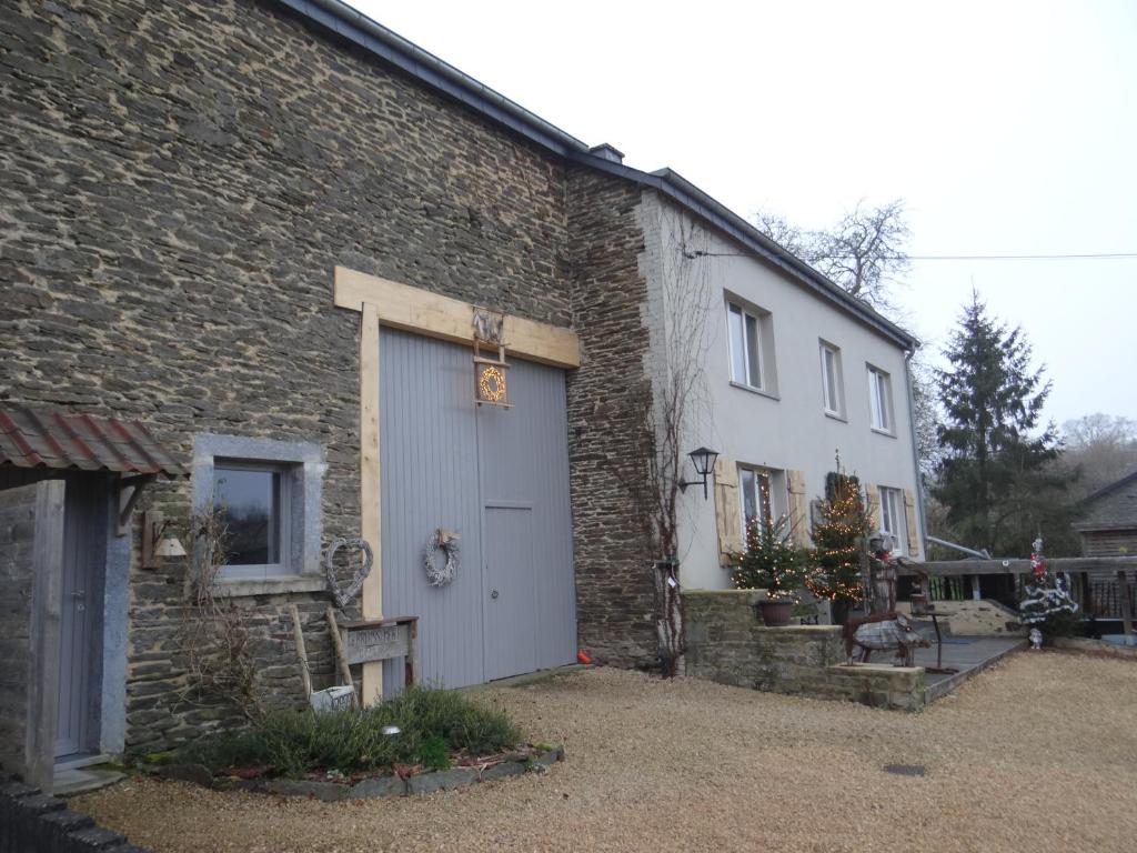 a brick building with a white door on it at B&B Le bruissement in Bièvre