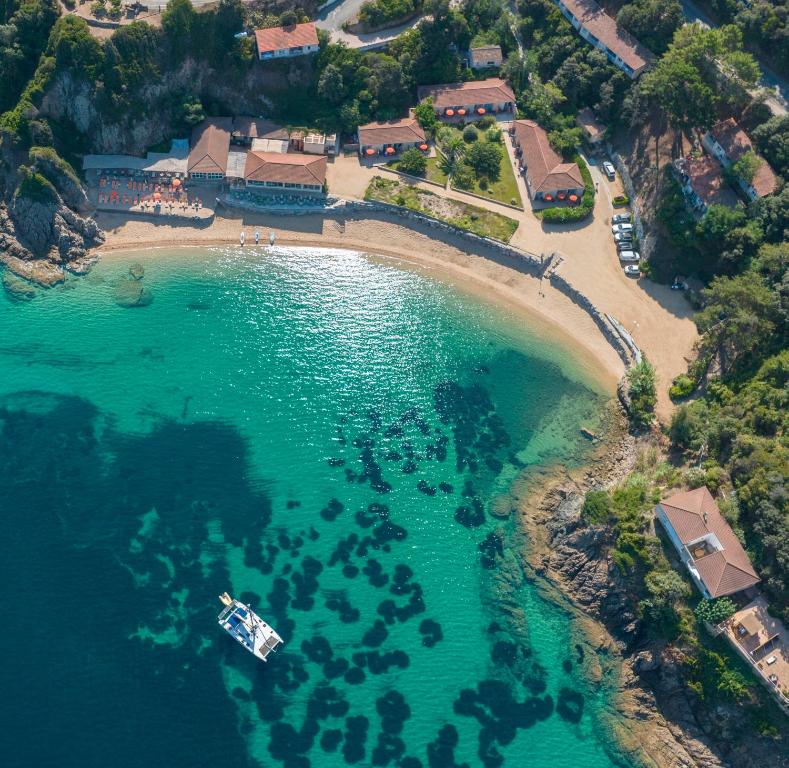 - une vue aérienne sur une plage avec un bateau dans l'eau dans l'établissement Hôtel Sampiero, à Propriano