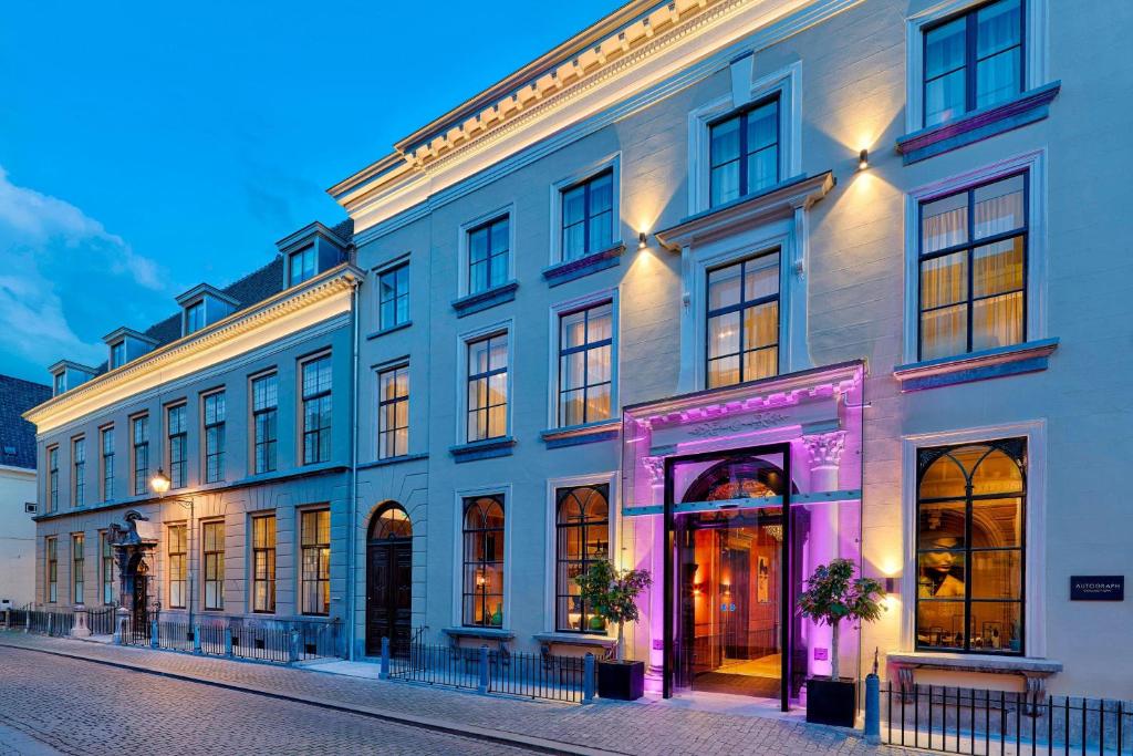 a large white building with a purple facade at Hotel Nassau Breda, Autograph Collection in Breda