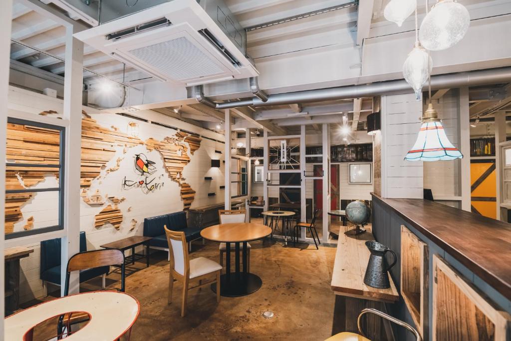 高松市にあるKotori Coworking & Hostel Takamatsuのテーブルと椅子のあるレストラン、バー