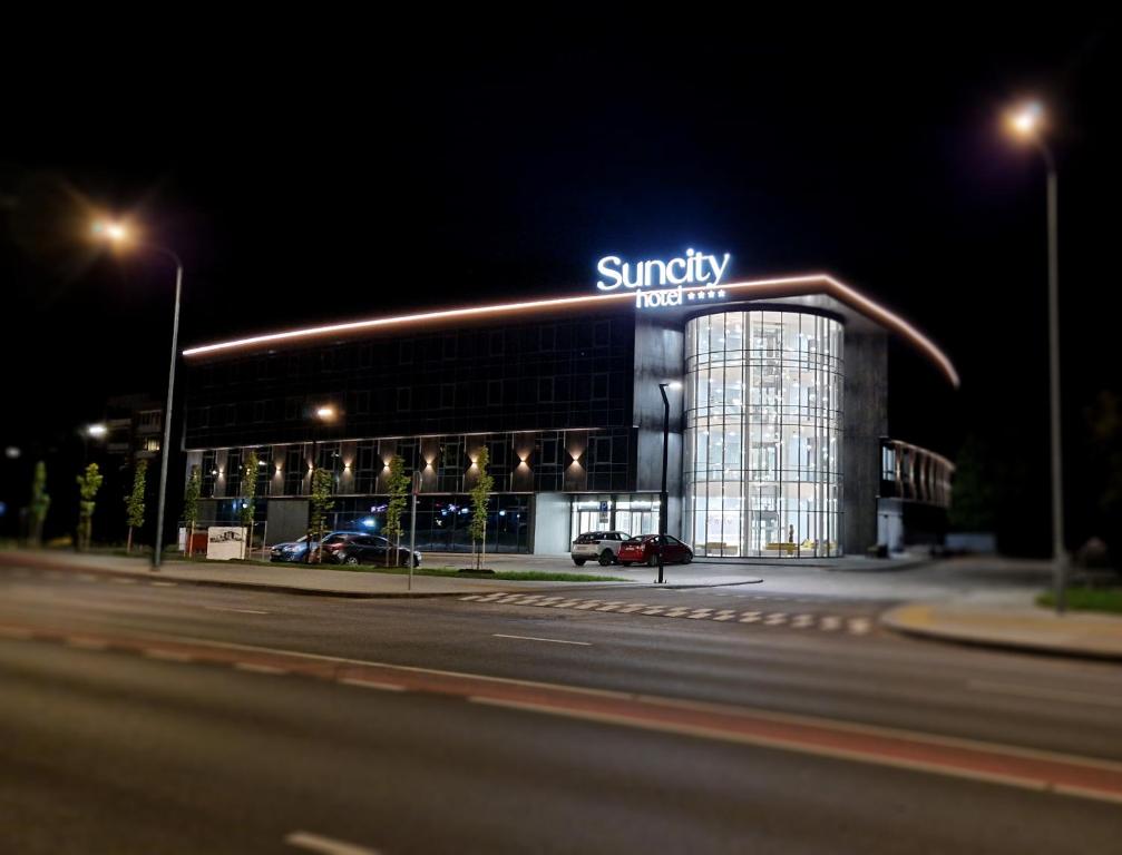 a large building with a sign on it at night at Suncity Hotel & SPA in Šiauliai