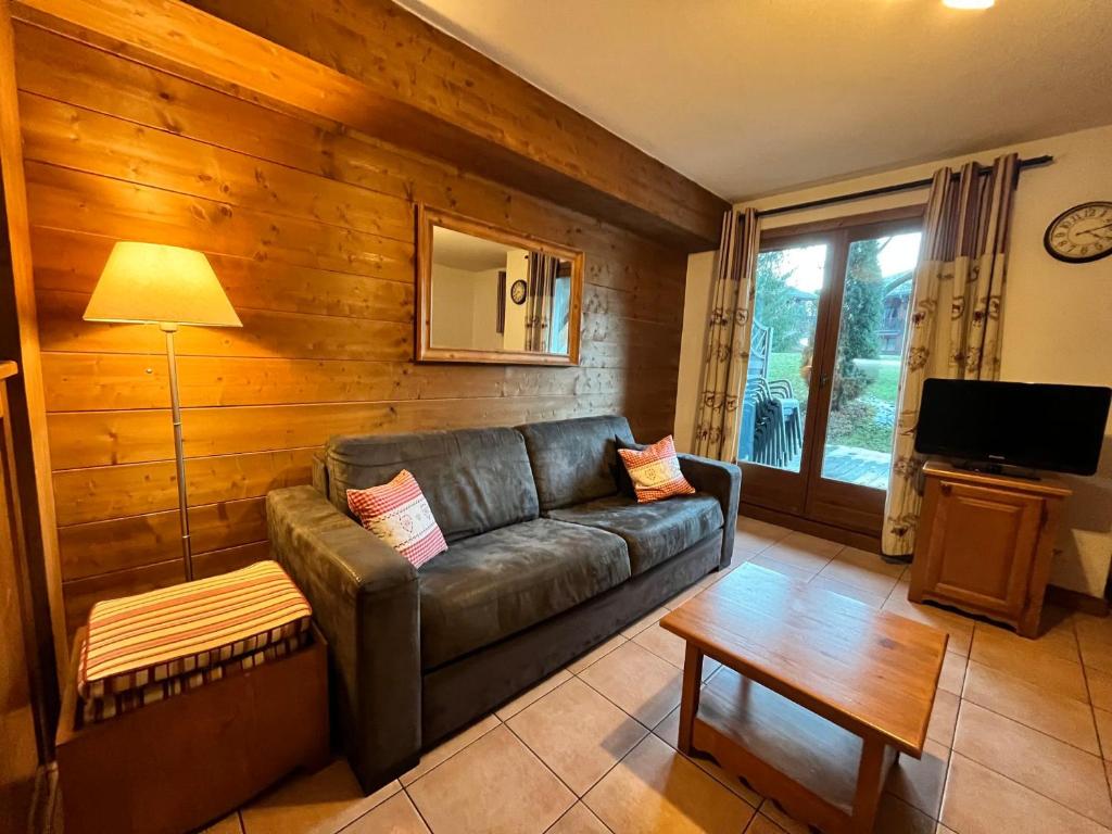 ein Wohnzimmer mit einem Ledersofa und einem Tisch in der Unterkunft Appartement triplex avec piscine, parking, animaux acceptés - FR-1-624-169 in Samoëns