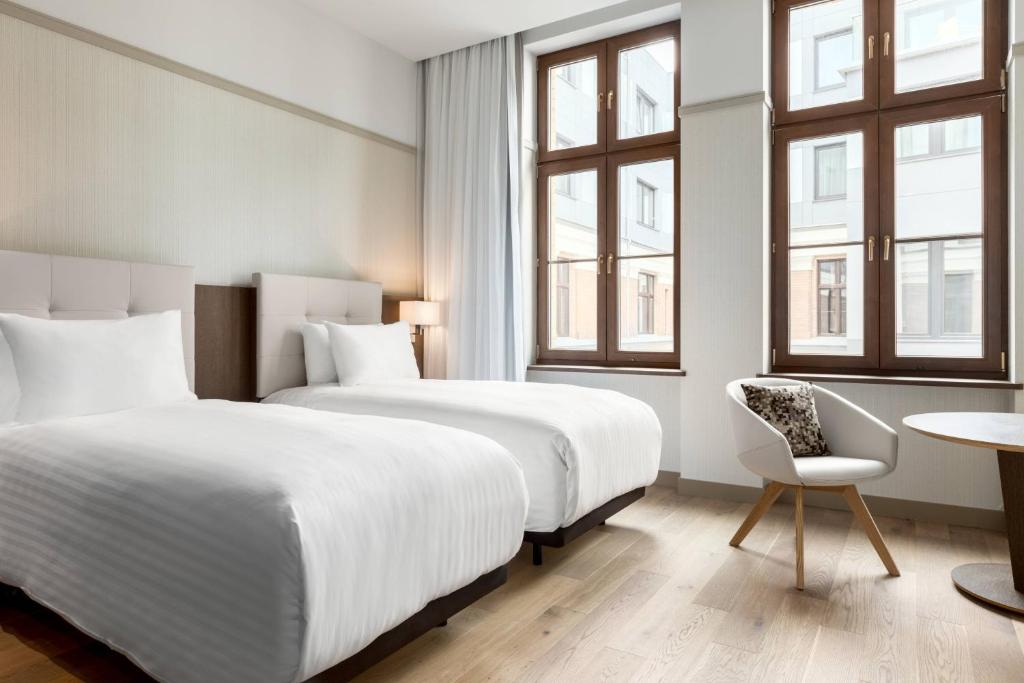 Pokój hotelowy z 2 łóżkami i krzesłem w obiekcie AC Hotel by Marriott Wroclaw we Wrocławiu