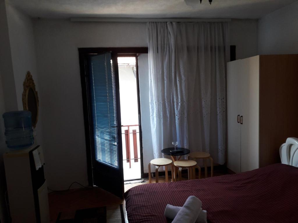 een slaapkamer met een bed en een deur naar een balkon bij Rooms Struga in Struga