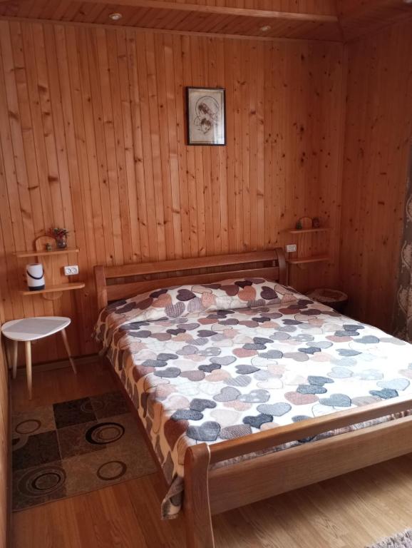 1 dormitorio con 1 cama en una habitación de madera en Карпатські ночі, en Yaremche