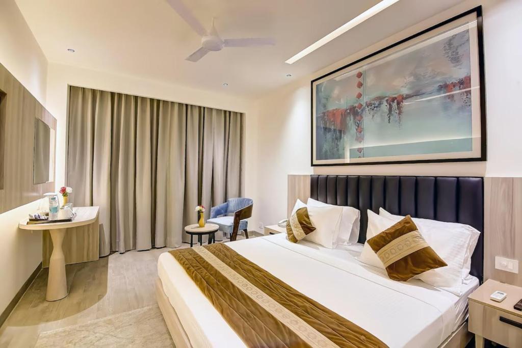 a hotel room with a large bed and a desk at Hotel Mehul Int-New Delhi in New Delhi