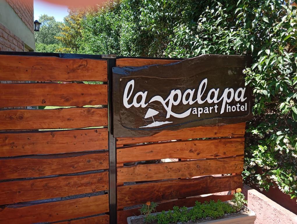 un letrero para la palapa agente hotel en una valla en La Palapa ApartHotel, en Villa General Belgrano