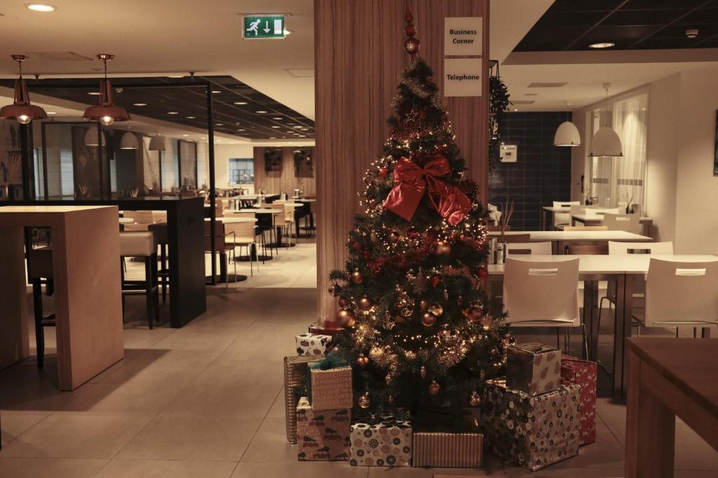 uma árvore de Natal no meio de um restaurante em Holiday Inn Express Rotterdam - Central Station, an IHG Hotel em Roterdão