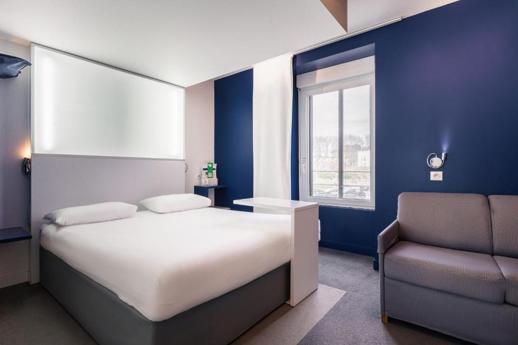 una camera con un letto, una sedia e una finestra di ibis Styles Vannes Gare Centre a Vannes