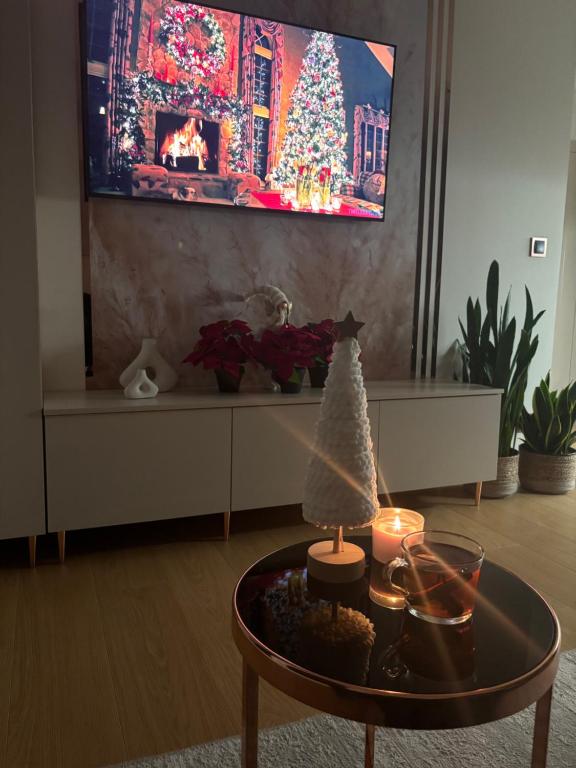 ein Wohnzimmer mit einem TV und einem Tisch mit einem Weihnachtsbaum in der Unterkunft Apartament JP Jastrzębia in Jastrzębia Góra