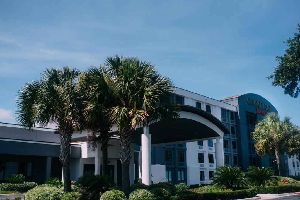 een hotel met palmbomen ervoor bij Courtyard by Marriott Gulfport Beachfront in Gulfport