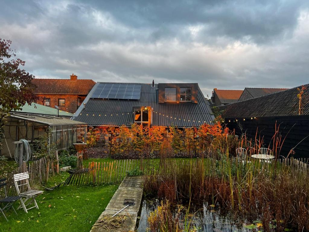 ein Haus mit Sonnenkollektoren darüber in der Unterkunft B&B Maas en Heuvel Maastricht in Maastricht