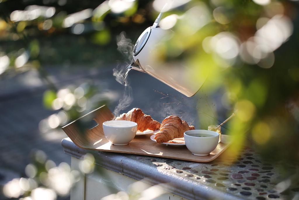 un plato de comida con dos tazas y cruasanes en Pas Juste, en Nida