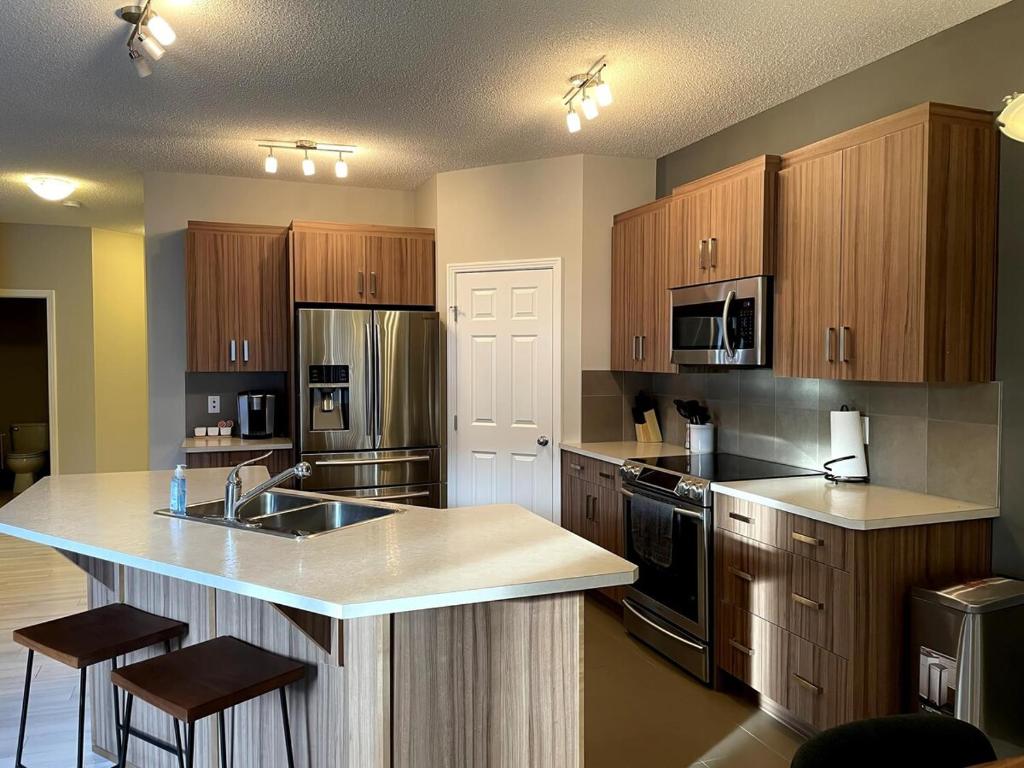 cocina grande con armarios de madera y encimera en Cozy 3 Bedroom home, en Spruce Grove