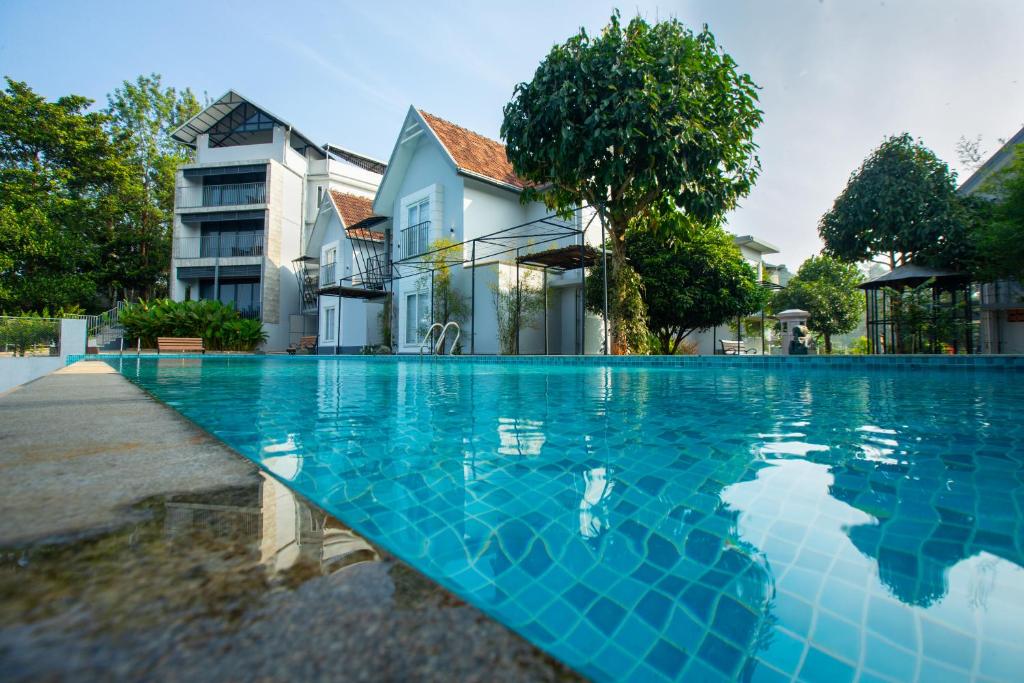 una piscina azul frente a una casa en Vbrings Oak Village, en Munnar