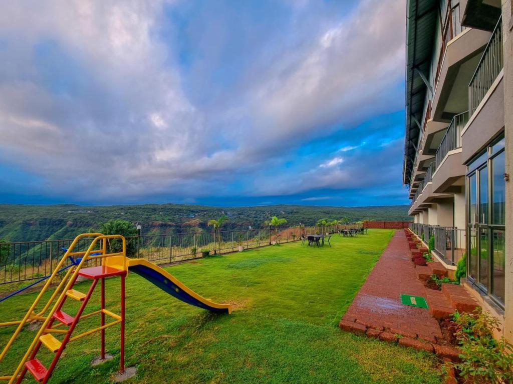 un toboggan dans une cour à côté d'un bâtiment dans l'établissement Mountain Breeze Resort, Mahabaleshwar, à Mahabaleshwar