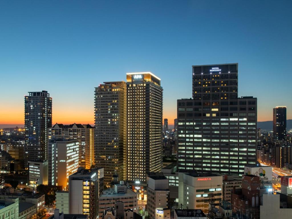 un perfil urbano con edificios altos por la noche en APA Hotel & Resort Osaka Namba Ekimae Tower, en Osaka