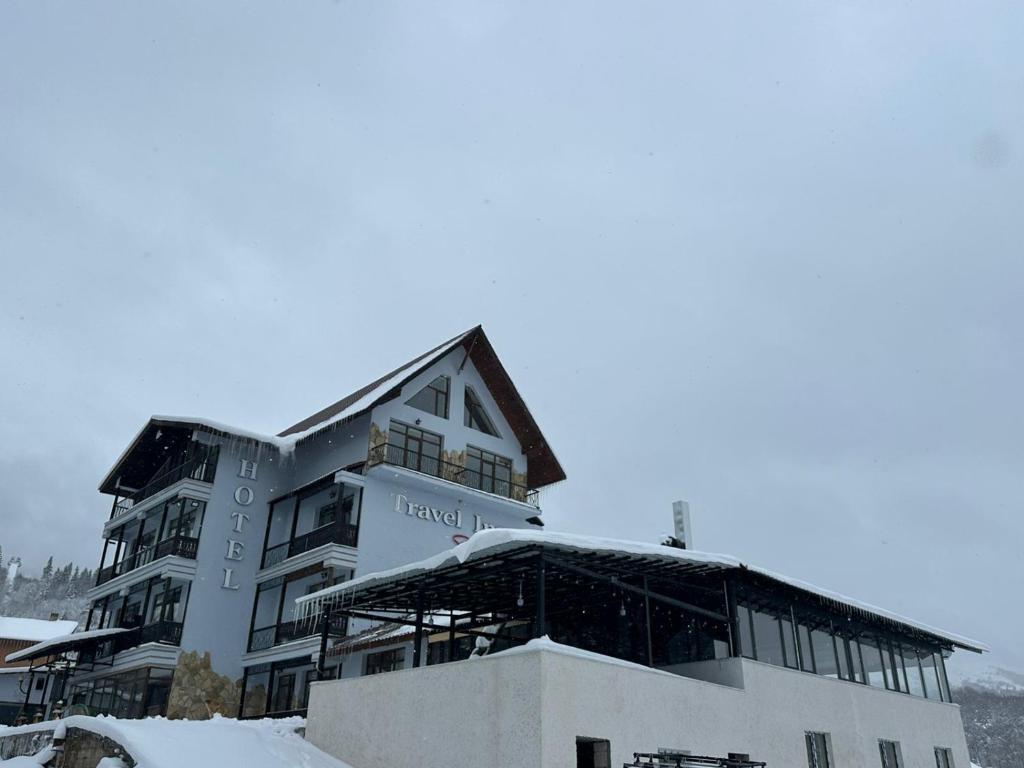 un grande edificio con neve sul terreno di Travel Inn Bakuriani a Bakuriani