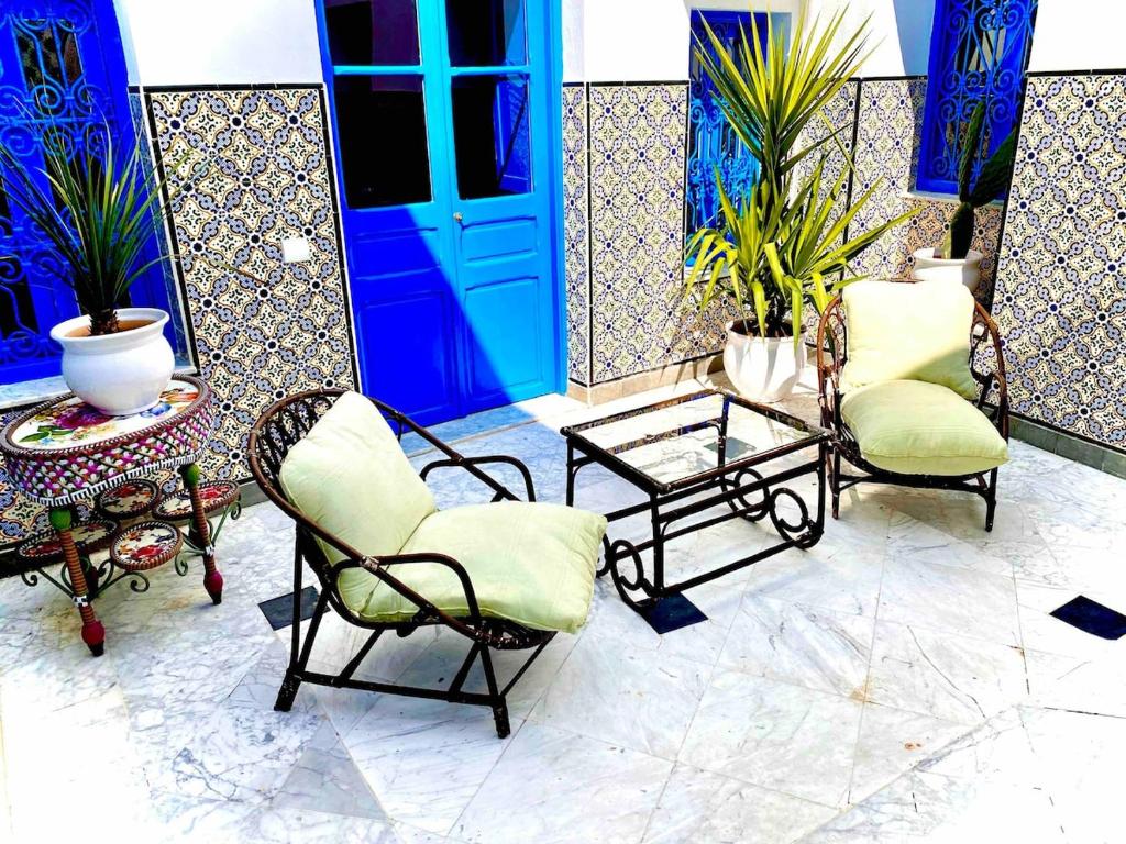 a group of chairs and a table and a blue door at Dar Saida in Sidi Bou Saïd