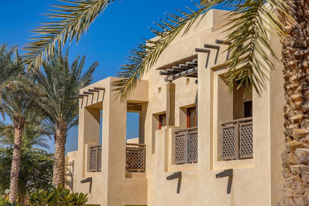 Al Wathba, a Luxury Collection Desert Resort & Spa, Abu Dhabi في أبوظبي: عماره امامها نخيل