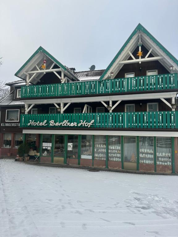 un grande edificio verde con neve di fronte di Hotel Berliner Hof a Braunlage