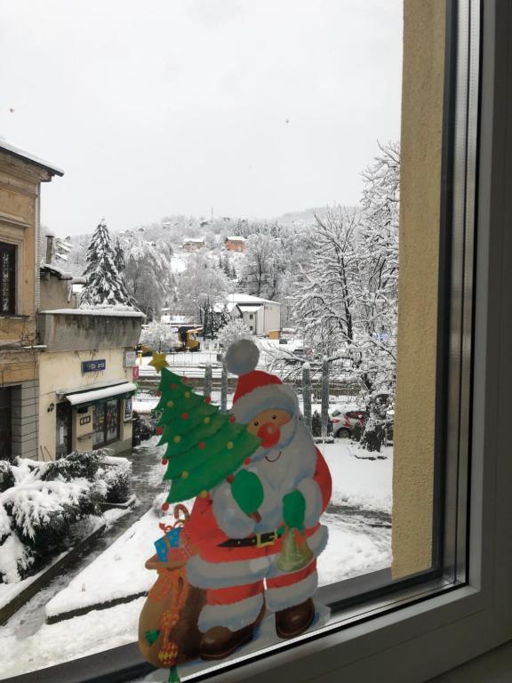 een glazen raam met een sneeuwpop met een kerstboom bij Travnik Nostalgia Apartment in Travnik