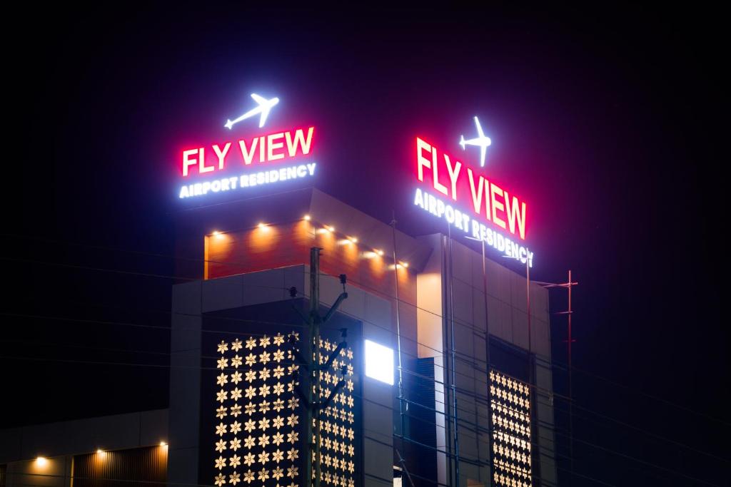 尼杜巴塞莱FLY VIEW Airport Residency的一座建筑物,上面有 ⁇ 虹灯标志