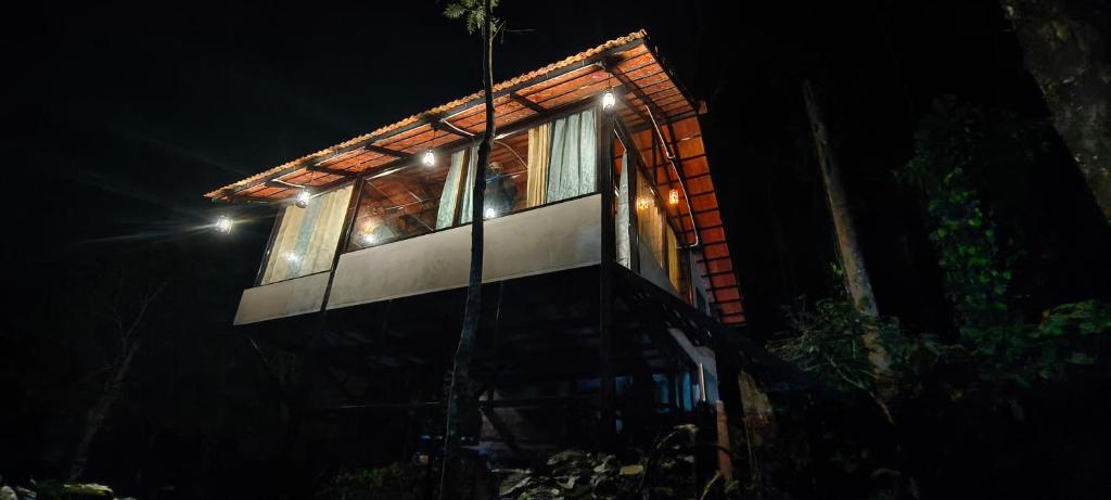 una casa iluminada por la noche con luces en Horanadu Haranamakki Homestay, en Kalasa