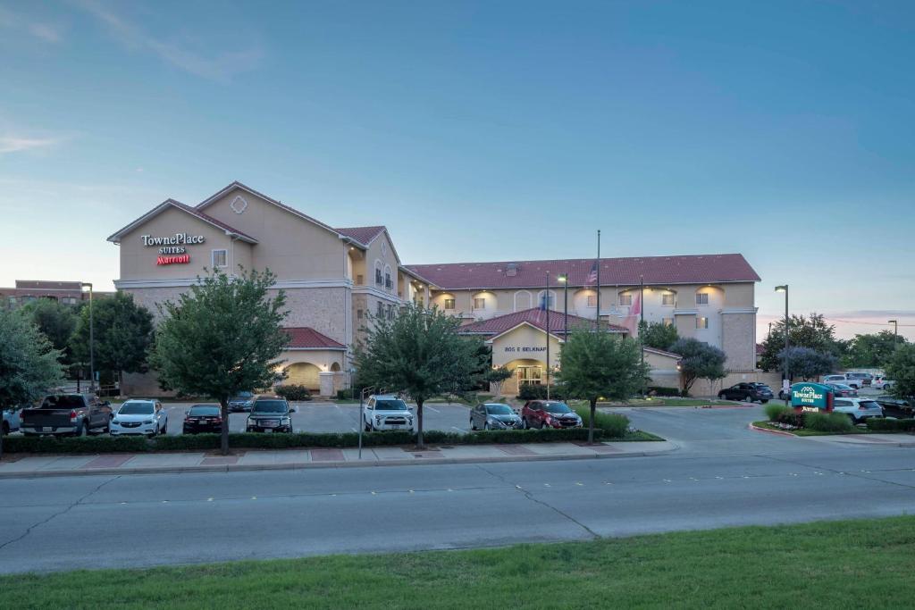 un grande edificio con auto parcheggiate in un parcheggio di TownePlace Suites Fort Worth Downtown a Fort Worth