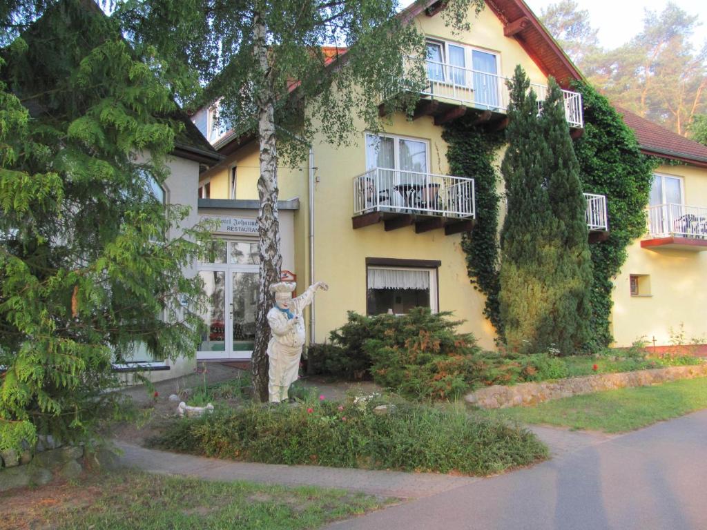 uma mulher em pé em frente a uma casa em Natur& Waldhotel Johannesruh em Wesenberg