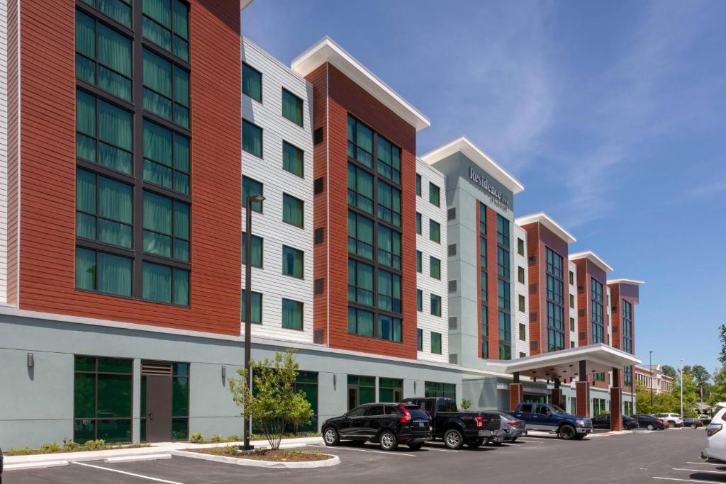 弗吉尼亚海滩Residence Inn by Marriott Virginia Beach Town Center的停车场内一排有汽车的建筑