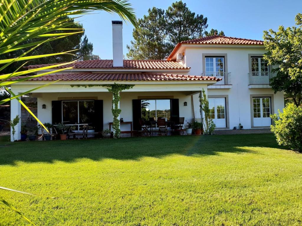 een groot wit huis met een tuin bij Casa do Campo - Castelo Branco in Castelo Branco