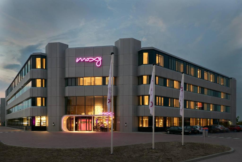 um grande edifício com um sinal de Wysiwyg em Moxy Amsterdam Schiphol Airport em Hoofddorp