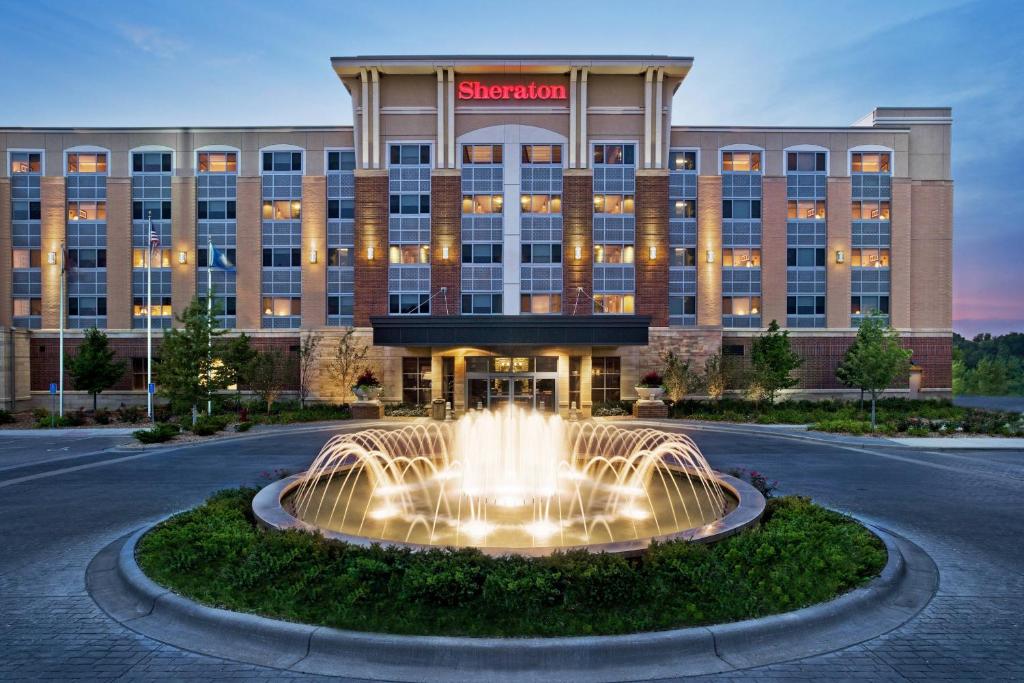 un hôtel avec une fontaine en face d'un bâtiment dans l'établissement Sheraton St Paul Woodbury Hotel, à Woodbury