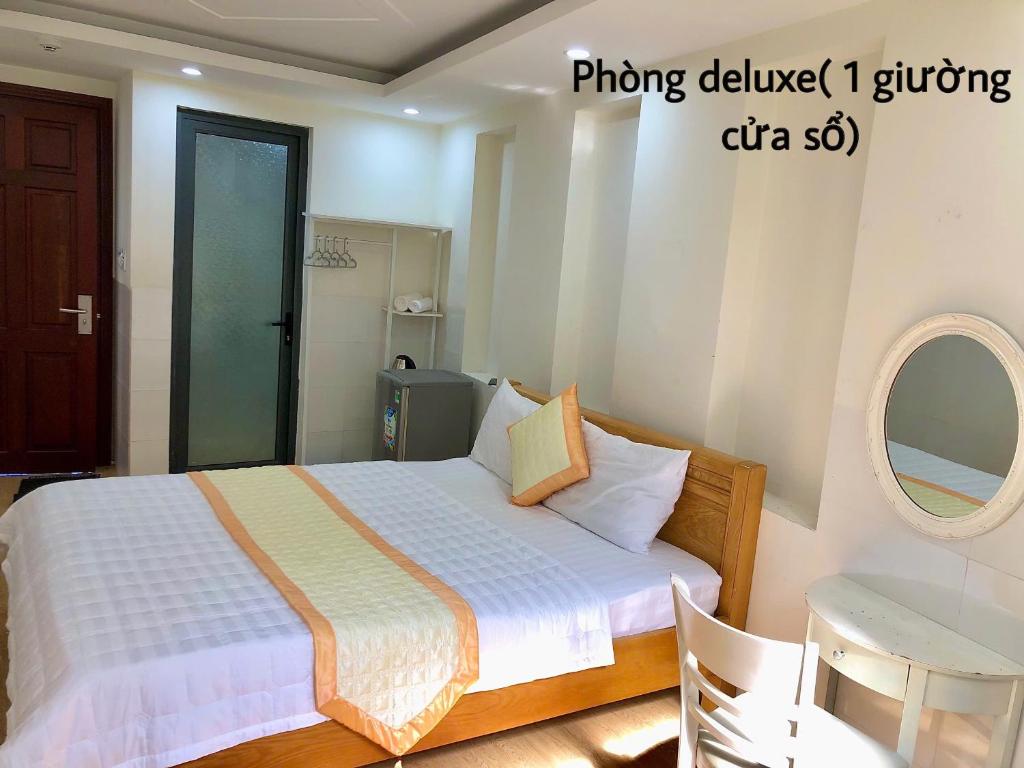 een slaapkamer met een bed, een tafel en een spiegel bij Hotel Rocket in Vung Tau